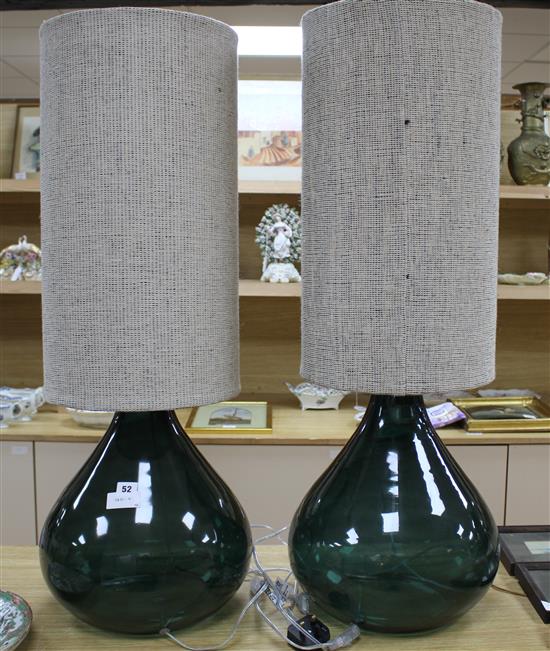 A pair of green glass lamp bases with cylindrical fabric shades, height overall 94cm, diameter 34cm